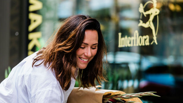 Kvinna handlar växter utanför en blomsterbutik i Mölndals innerstad
