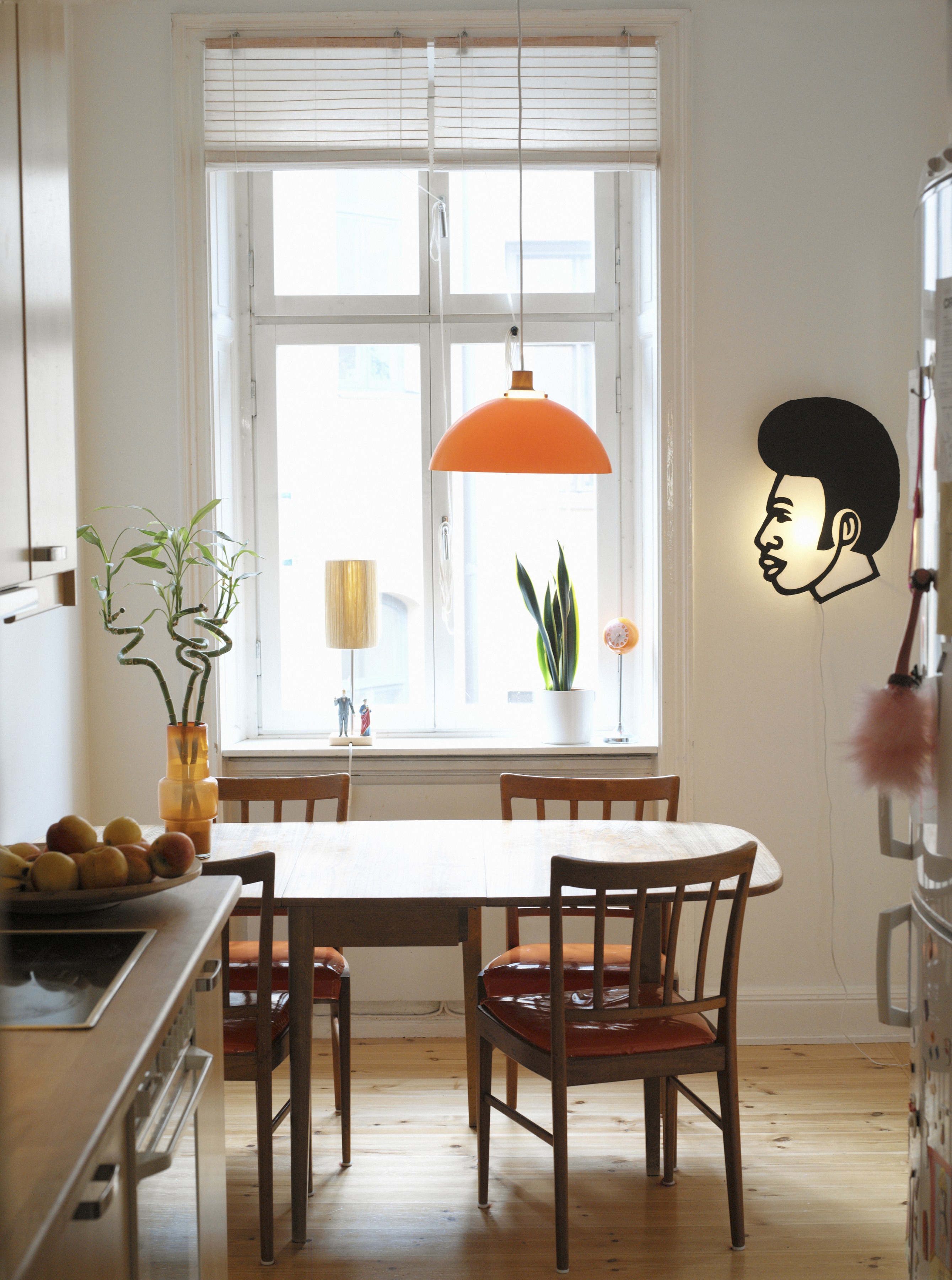 Ett kök som visar lite olika lampor som kökslampa, bordslampa i fönstret och en mysbelysning på väggen.