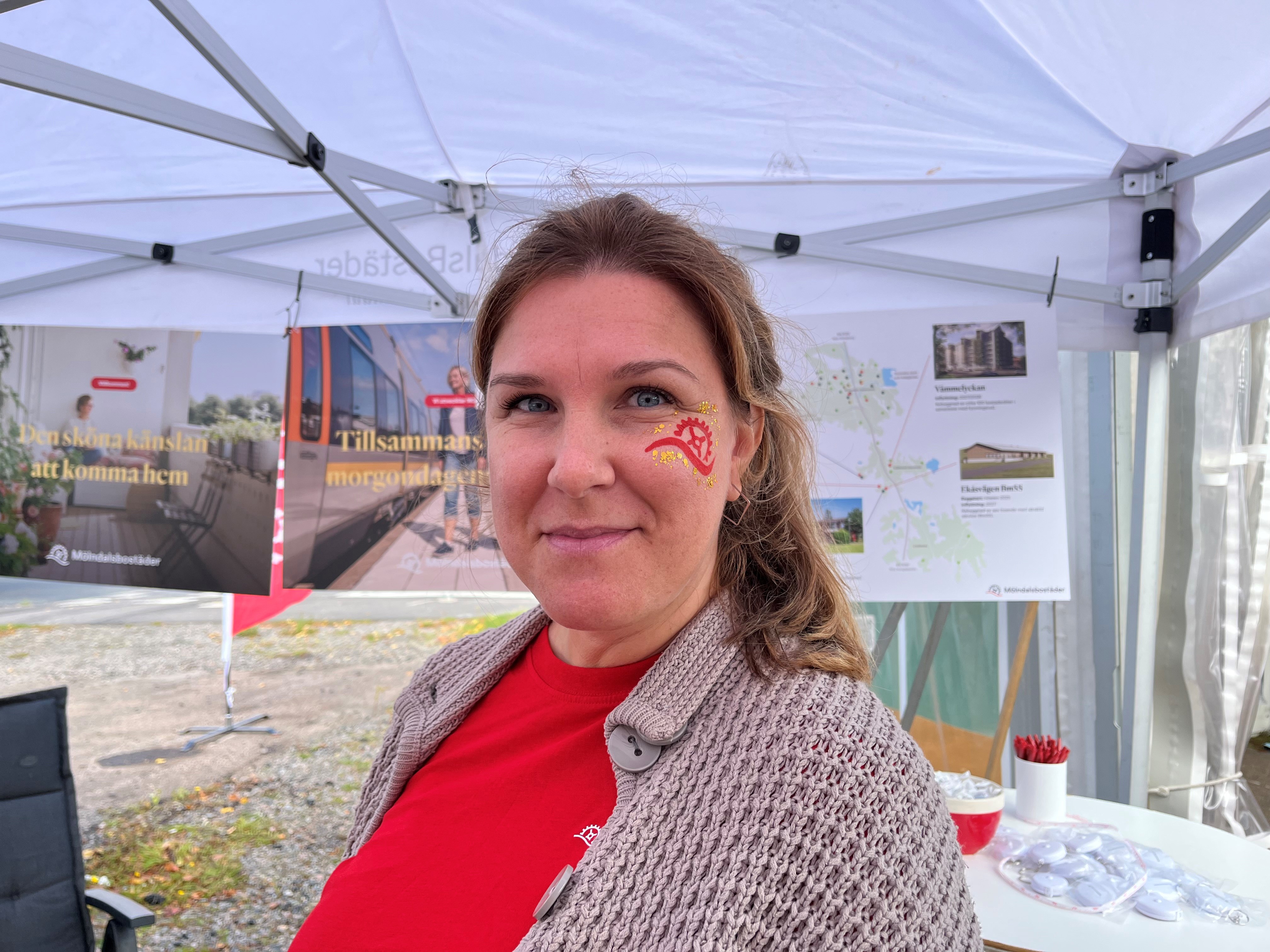 Kvinna med ansiktsmålning på kinden ler 