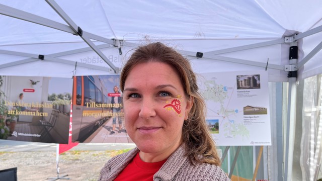 Kvinna med ansiktsmålning på kinden ler 