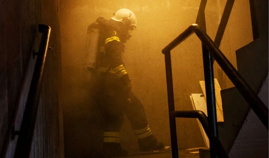 Brandman rör sig i en rökfylld trappuppgång i ett flerfamiljshus